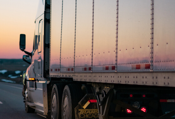 Semi Truck Driving at Sunset